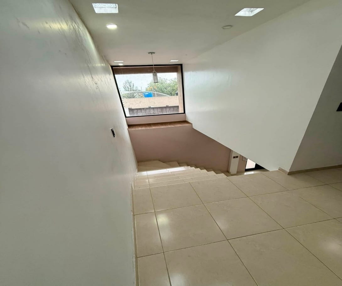 Escalera y pasillo de la planta alta con ventanal