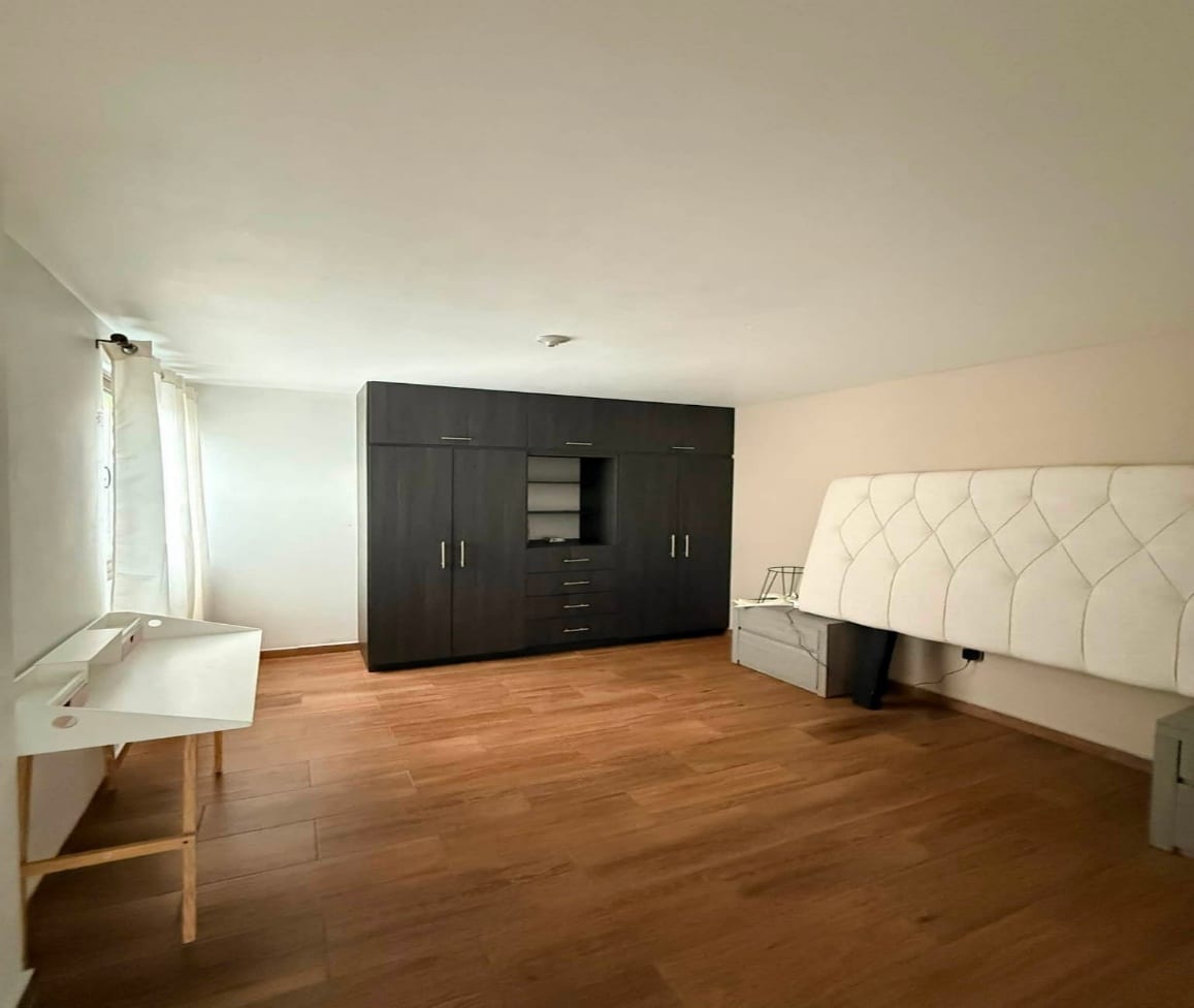 Recámara con clóset integrado y piso de madera