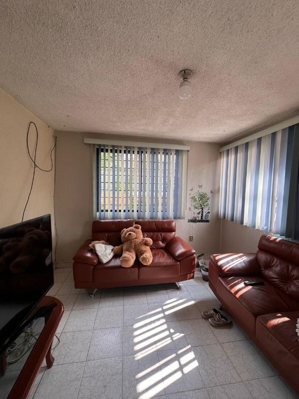 Sala con ventanas hacia la calle y escalera de caracol al fondo