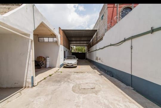 Patio de estacionamiento techado al fondo, con acceso desde la calle