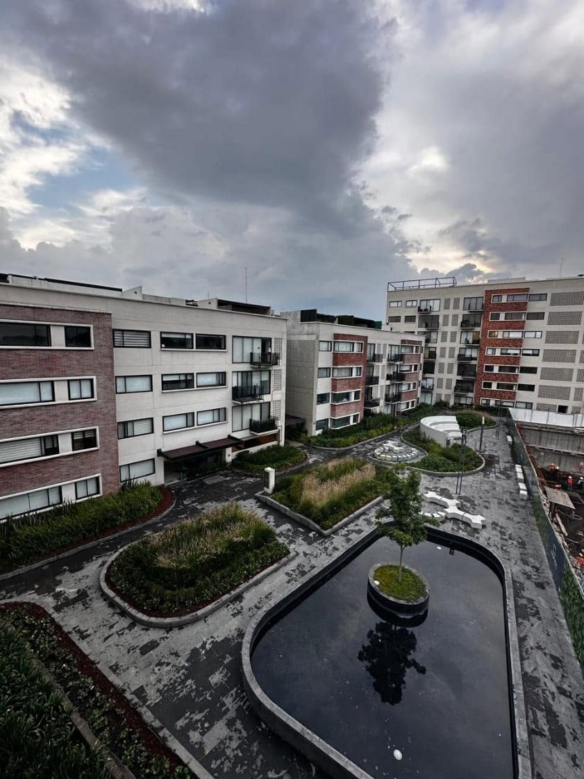 Vista desde lo alto del patio central del conjunto, con andadores, jardineras y espejo de agua
